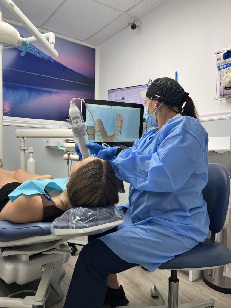 Assistant scanning teeth showing the captured image on a screen